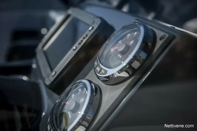 Close-up of a dashboard featuring two round dials alongside a digital display, indicating a modern vehicle's controls.